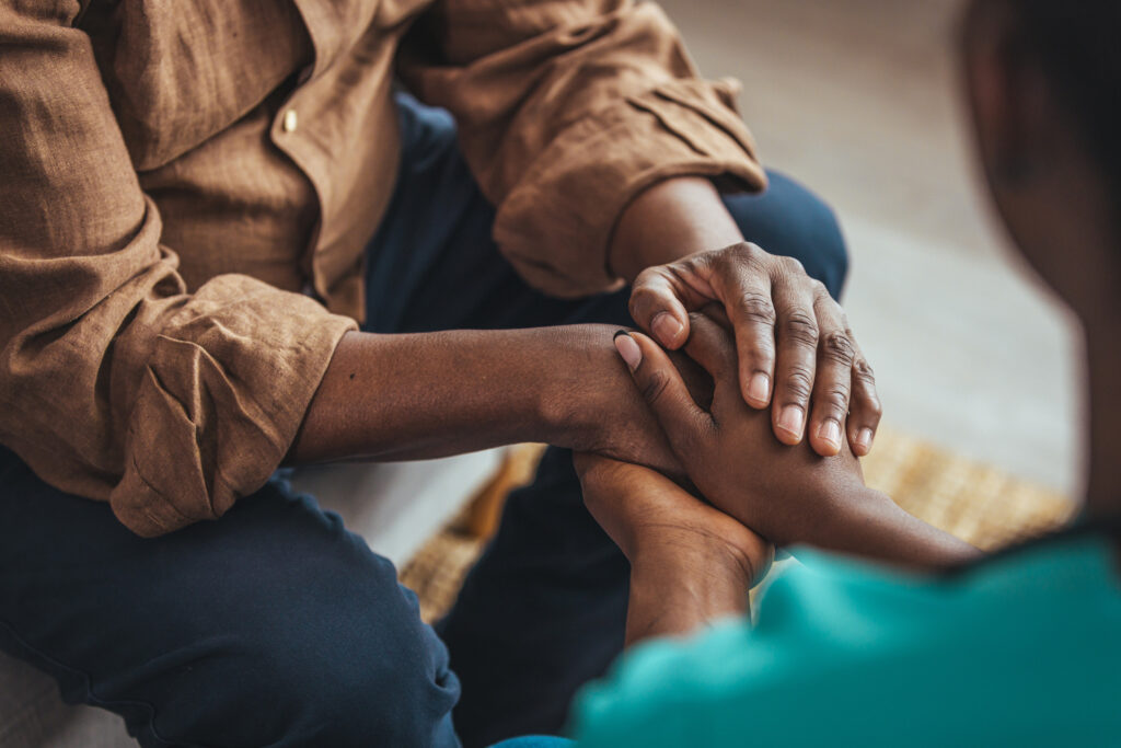 Image of two people holding hands.