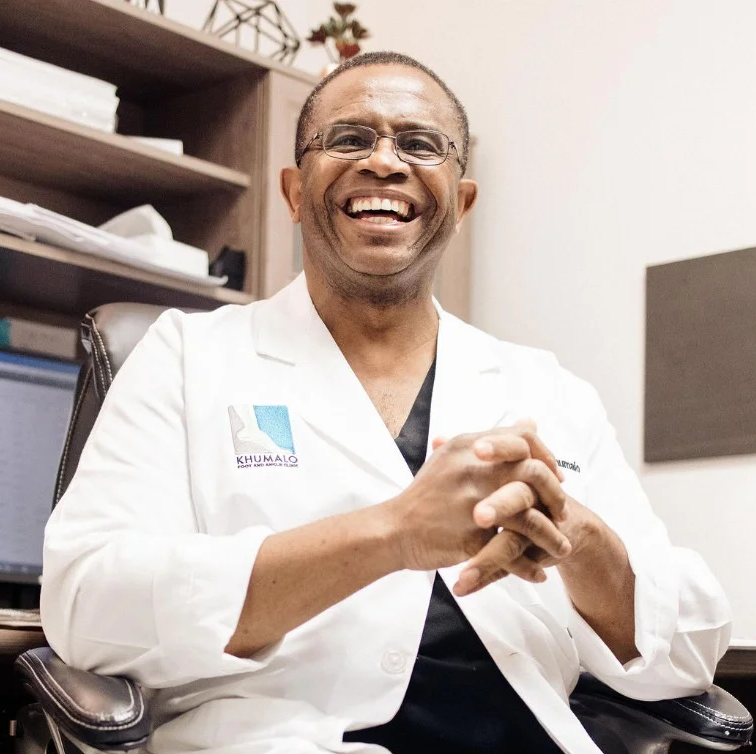 Image of Dr. Khumalo sitting at his desk smiling.